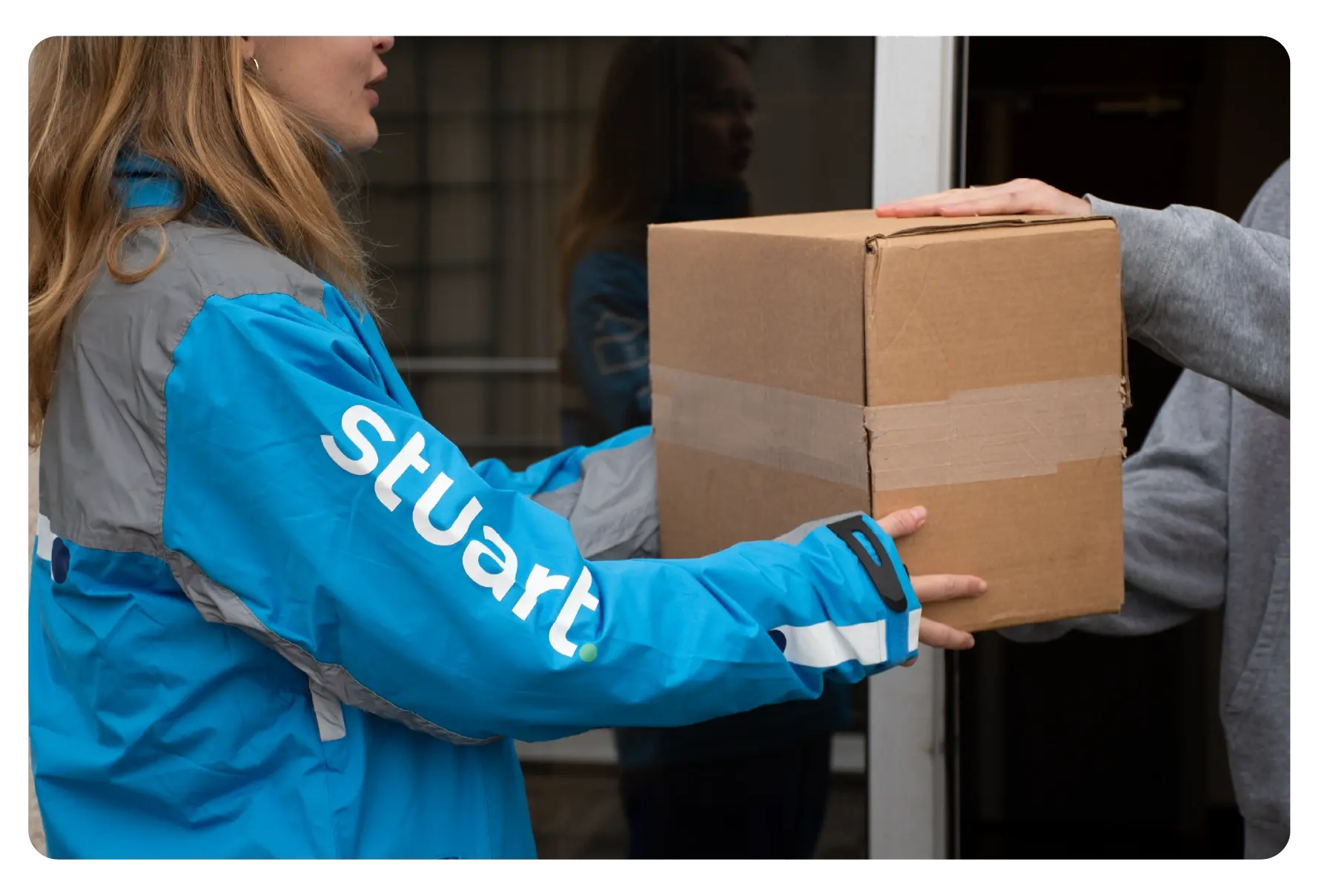 The courier hands over the parcel to the recipient